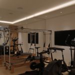 basement gym with lit coffer and slots through to the staircase beyond