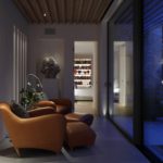contemporary seating space with slatted ceiling and glazing on to the garden and the bedroom lit beyond