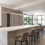 long kitchen with pendant over island and dining table beyond