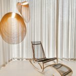 Decorative lighting pendant suspended above chair