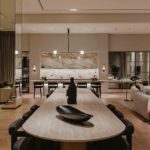 View across dining table to kitchen beyond with luxury lighting